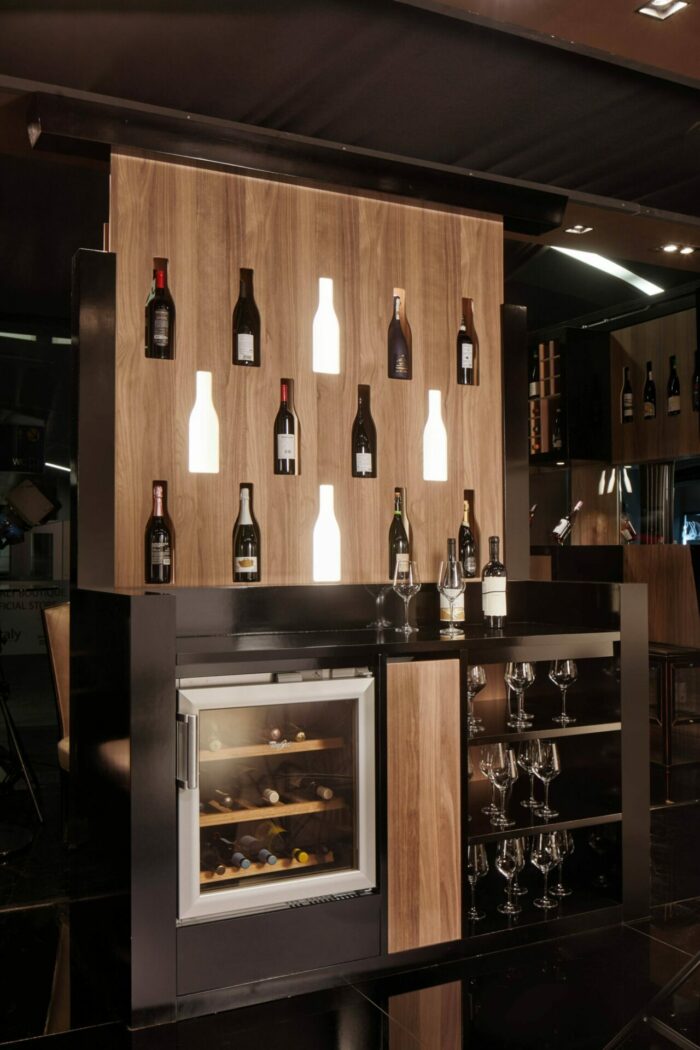 70.09 - Parete bifacciale con funzione portabottiglie retro illuminata, sul retro zona bar con piano di appoggio, predisposizione per cantinetta, e colonna estraibile